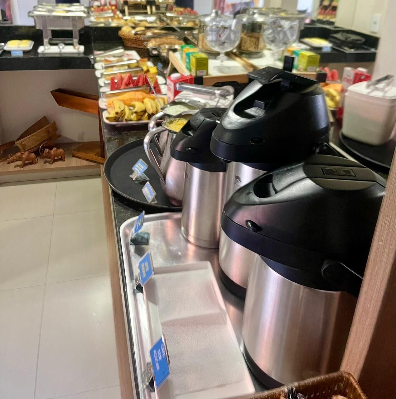 Un espace buffet proposant une variété de plats et un coin café équipé de plusieurs machines à café.