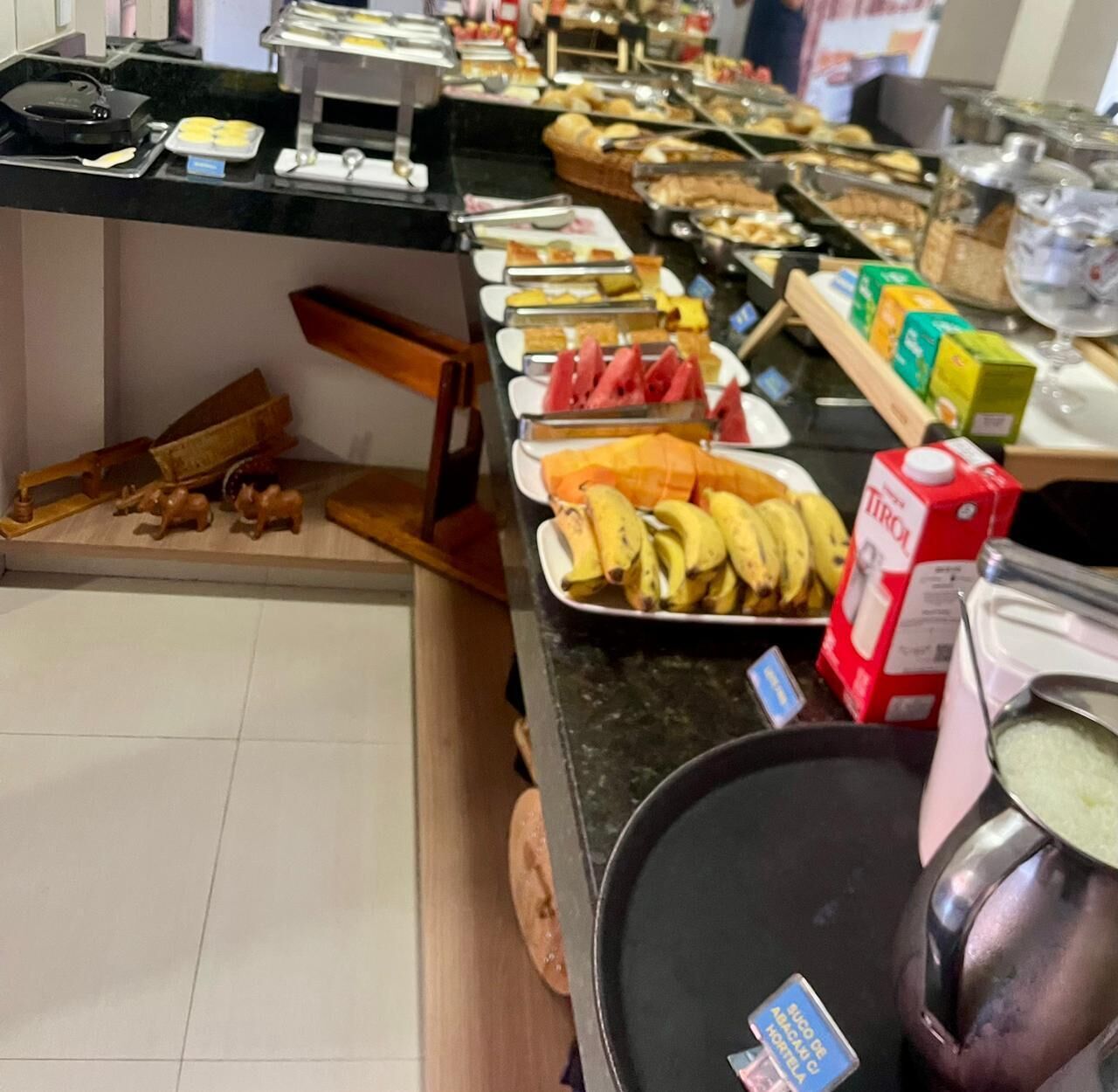 A buffet with various food items and a juice dispenser.