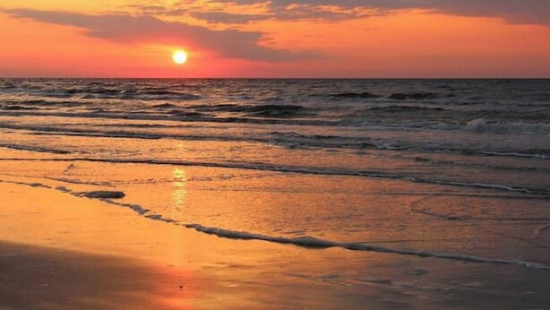 A sunset over the ocean with waves approaching the shore. - Beach Escape Seawall View 2 Pool (Galveston)