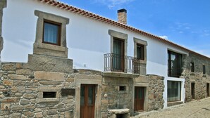 A traditional stone building with a white facade, multiple windows, and a stone staircase leading to the entrance. - Casa dos Poços (Figueira de Castelo Rodrigo)