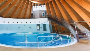 An indoor swimming pool with a wooden ceiling and a staircase leading to an upper level. - Casa dos Poços (Figueira de Castelo Rodrigo)