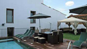 Een seizoensgebonden buitenzwembad, parasols voor strand/zwembad