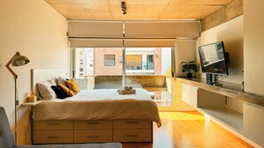A modern bedroom with a bed, bedside lamp, and a TV. - BT Homes - Palermo, Soler (Buenos Aires)