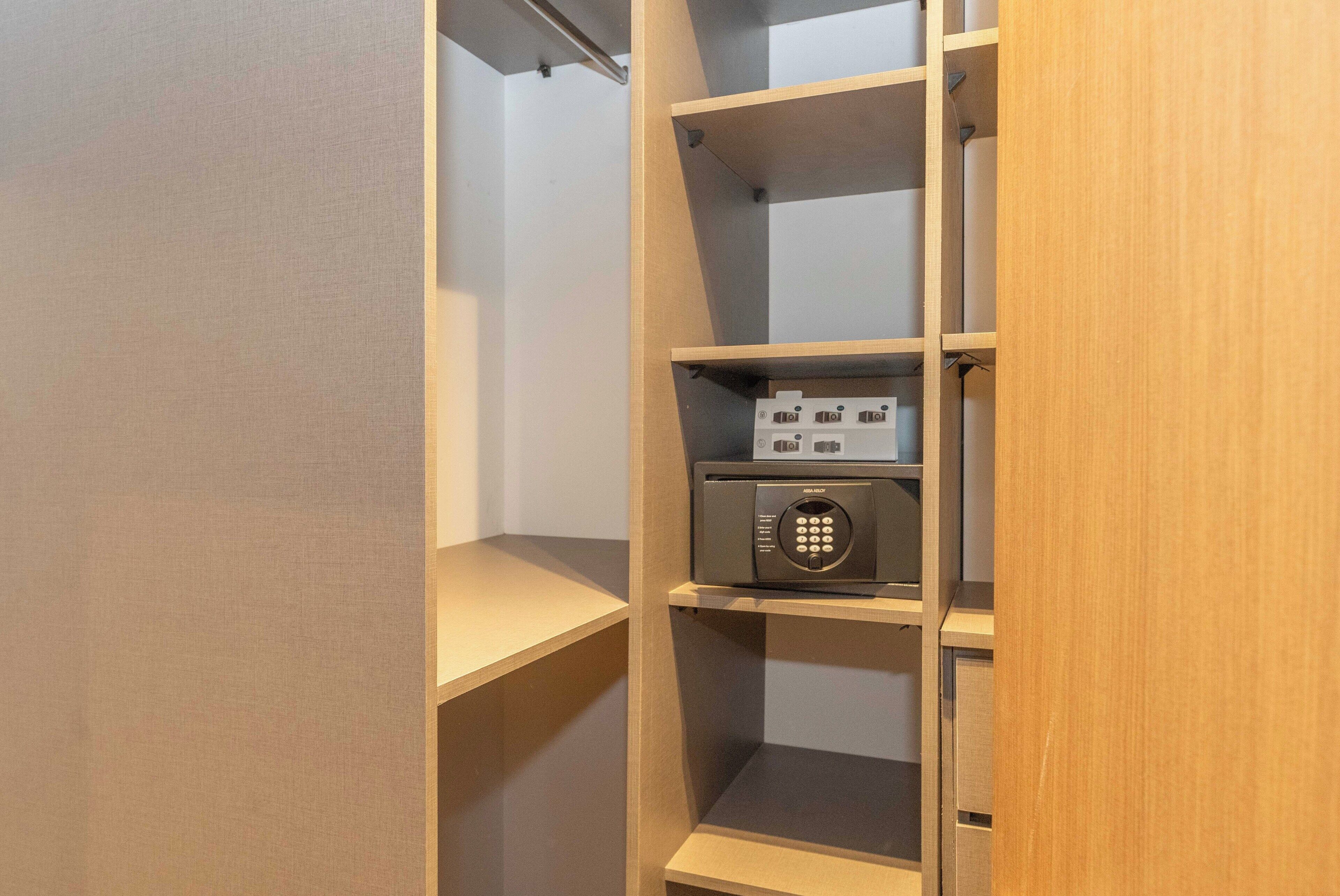 Una estantería de madera con un dispositivo electrónico negro en el estante central.