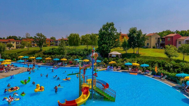A swimming pool with a water slide and multiple umbrellas. - Holiday Apartment with Pool (Castelnuovo del Garda)
