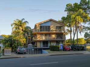 A two-story building with a balcony on the upper floor, surrounded by palm trees. - Stunner 2 min walk to beach & cafes (Torquay)