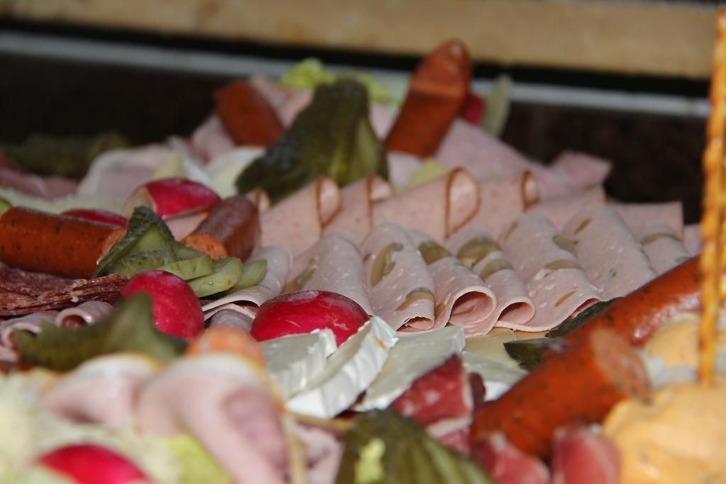 A variety of sliced meats and vegetables on a platter.