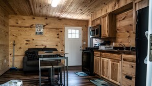A cozy cabin-style kitchen with wooden walls, a black refrigerator, and a microwave. - Charming 2-bedroom Duplex in Albany, KY on Dale Hollow Lake with Slip #20 (Albany)