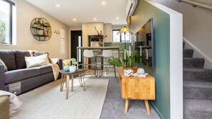 Uma sala moderna com um sofá, uma mesa de centro e um espaço de jantar com cadeiras.
