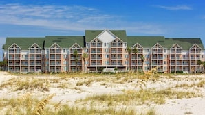 Et strandhotel med flere balkoner og et grønt tag.