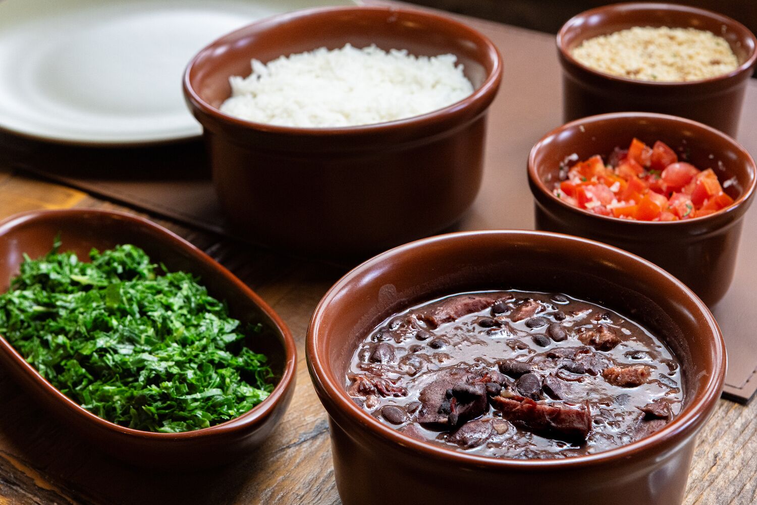 A table with various dishes including rice, beans, and a salad.