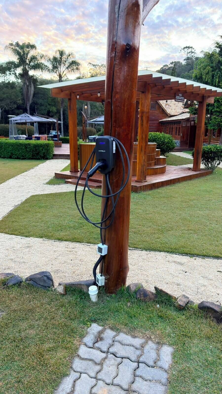 Een houten prieeltje met een stopcontact en kabel.