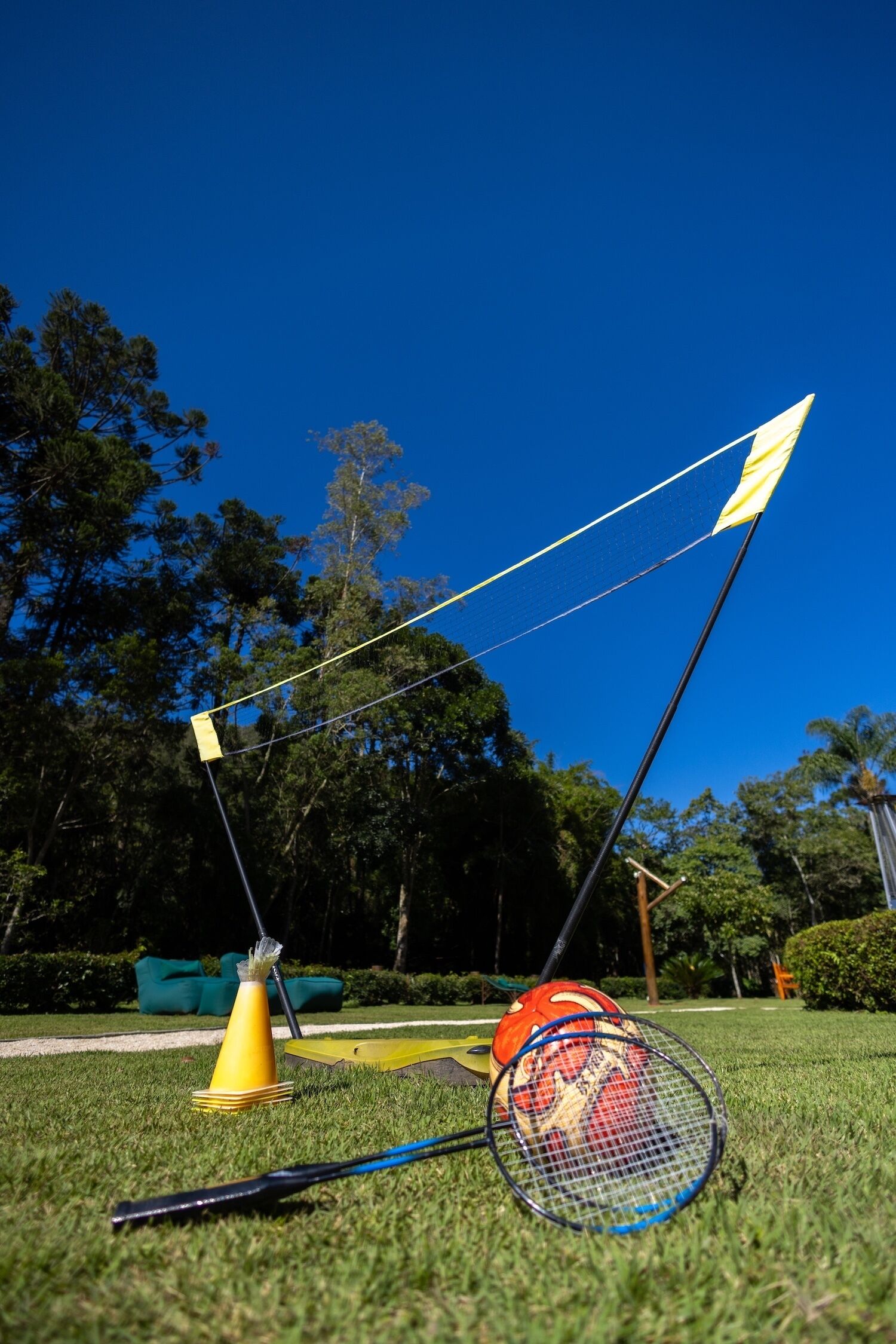 A badminton set on a grassy field with trees in the background.