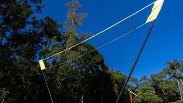 A badminton set on a grassy field with trees in the background.