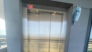 An elevator with a metallic finish and a sign above it. - one room apartment  (Hvidovre)