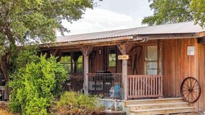 A rustic wooden building labeled "PUNCH HOUSE" with a porch, a large wheel, and a small step leading up to the entrance.