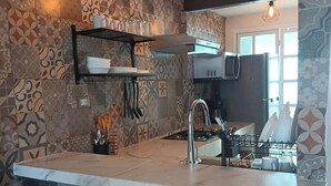 Eine moderne Küche mit Marmorarbeitsplatte, Holzhockern, ornamentalem Rücksprühen und Pendelleuchten.