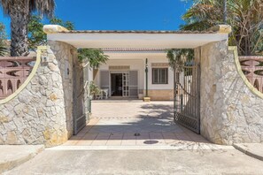Enter a Mediterranean-inspired haven with a beautifully maintained stone facade and a charming gated entrance.