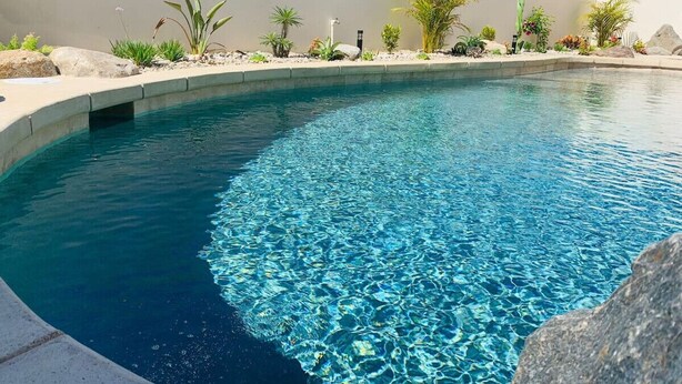 A clear blue pool with a curved edge, surrounded by a variety of plants and rocks. - Walkable Convenient in Downtown Los Barriles (Los Barriles)