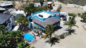 A resort with a pool, palm trees, and a beach area. - Heart of Los Barriles Ocean View and Pool (Los Barriles)