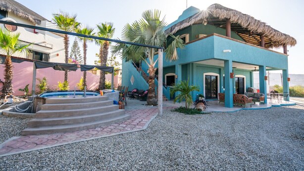 A two-story building with a pool, outdoor seating, and a staircase leading to the upper level. - Heart of Los Barriles Ocean View and Pool (Los Barriles)