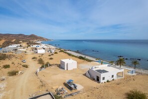 Une zone côtière avec des bâtiments, un chemin de terre et une plage.