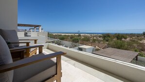 A balcony with a view of the beach and mountains. - Pool Condo, just a few steps from the beach -north (Los Barriles)