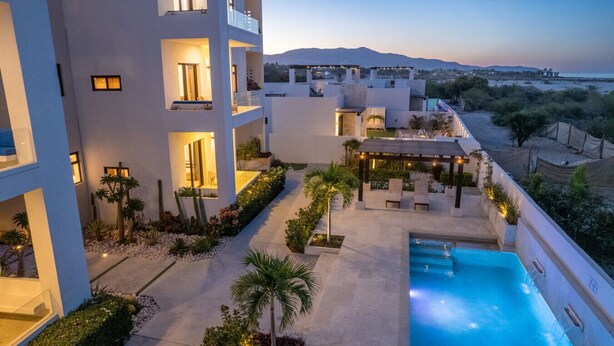 A modern hotel with a rooftop pool, outdoor seating, and a view of the mountains. - Pool Condo, just a few steps from the beach -north (Los Barriles)