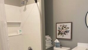 A bathroom with a shower, toilet, and sink.