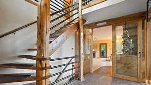 Una escalera de madera con barandillas de metal que conduce a una puerta de vidrio.