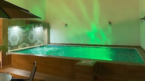 A swimming pool with a waterfall feature and green lighting. - Alberca privada con cascada familia/amigos

 (Cancún)