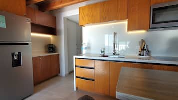 Fridge, microwave, coffee/tea maker, cookware/dishes/utensils