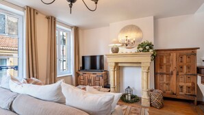 A cozy room with a fireplace, a television, and a bed with pillows. - Rock in Share - A la Fleur de Ly (Metz)