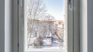 A window with a view of a snow-covered street and buildings. - Bright & Cozy, Renovated Studio in the Center (Lahti)