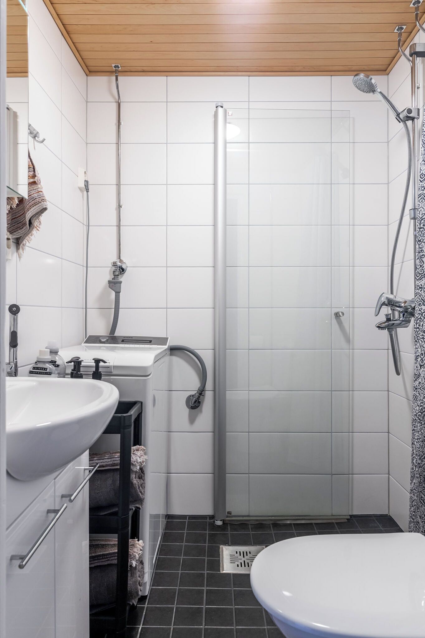 Une salle de bain équipée d’une douche, de toilettes, d’un lavabo et d’un porte-serviettes.