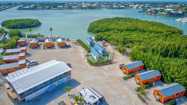 An aerial view of a coastal resort with multiple buildings, a marina, and lush greenery. - Charming 3-bedroom 2-bathroom house with Boat Ramp and Dockage in Marathon (Marathon)