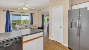 A kitchen with a dishwasher, a refrigerator, and a ceiling fan. - Charming 3-bedroom 2-bathroom house with Boat Ramp and Dockage in Marathon (Marathon)