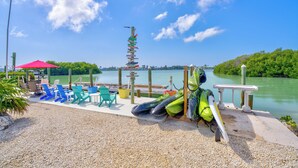 A waterfront area with chairs and kayaks, a dock, and a view of the water. - Charming 3-bedroom 2-bathroom house with Boat Ramp and Dockage in Marathon (Marathon)