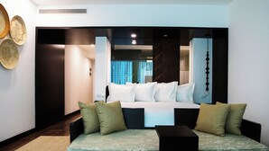 A modern hotel room with a large bed, a sofa, and a view of the bathroom.