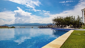 A swimming pool with a clear view of the sky and mountains in the background.