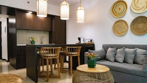 A modern kitchen with dark wood cabinets, a central island with chairs, and pendant lighting.