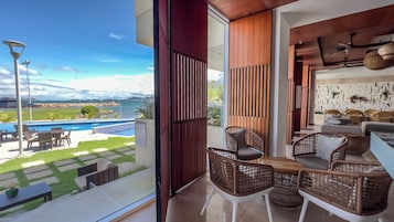 Uma sala de estar moderna com vista para uma piscina e montanhas.