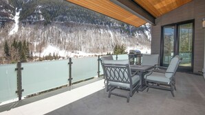 Ein Balkon mit Blick auf einen verschneiten Berg und einen See.