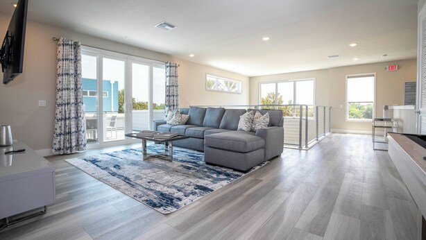 Un salón moderno con un sofá gris, una mesa de centro y una alfombra azul estampada.