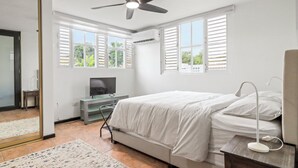 A bedroom with a bed, a desk, a television, and a ceiling fan. - Charming 4-bedroom Estate with In-ground pool WiFi in San Juan (Guaynabo)