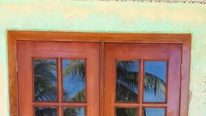Eine Holztür mit Glasschiebeelement, das eine Strandansicht spiegelt.