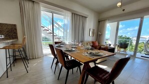A spacious dining area with a large wooden table set for six, surrounded by dark chairs. - Unique lake, Golf & Jacuzzi in Hard Rock Golf PC (Punta Cana)