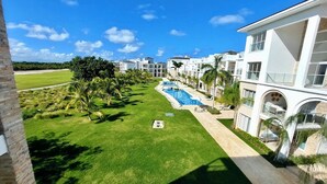 A resort with a swimming pool, palm trees, and a view of the ocean. - Unique lake, Golf & Jacuzzi in Hard Rock Golf PC (Punta Cana)