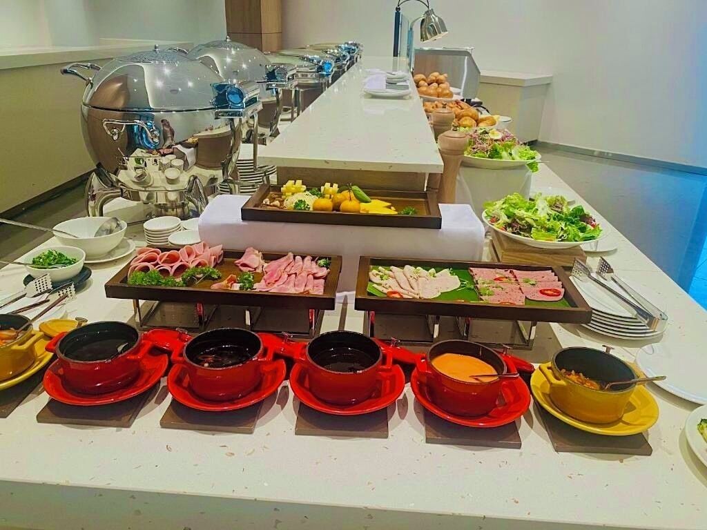 Montaje de bufé con diversos alimentos y bebidas calientes.