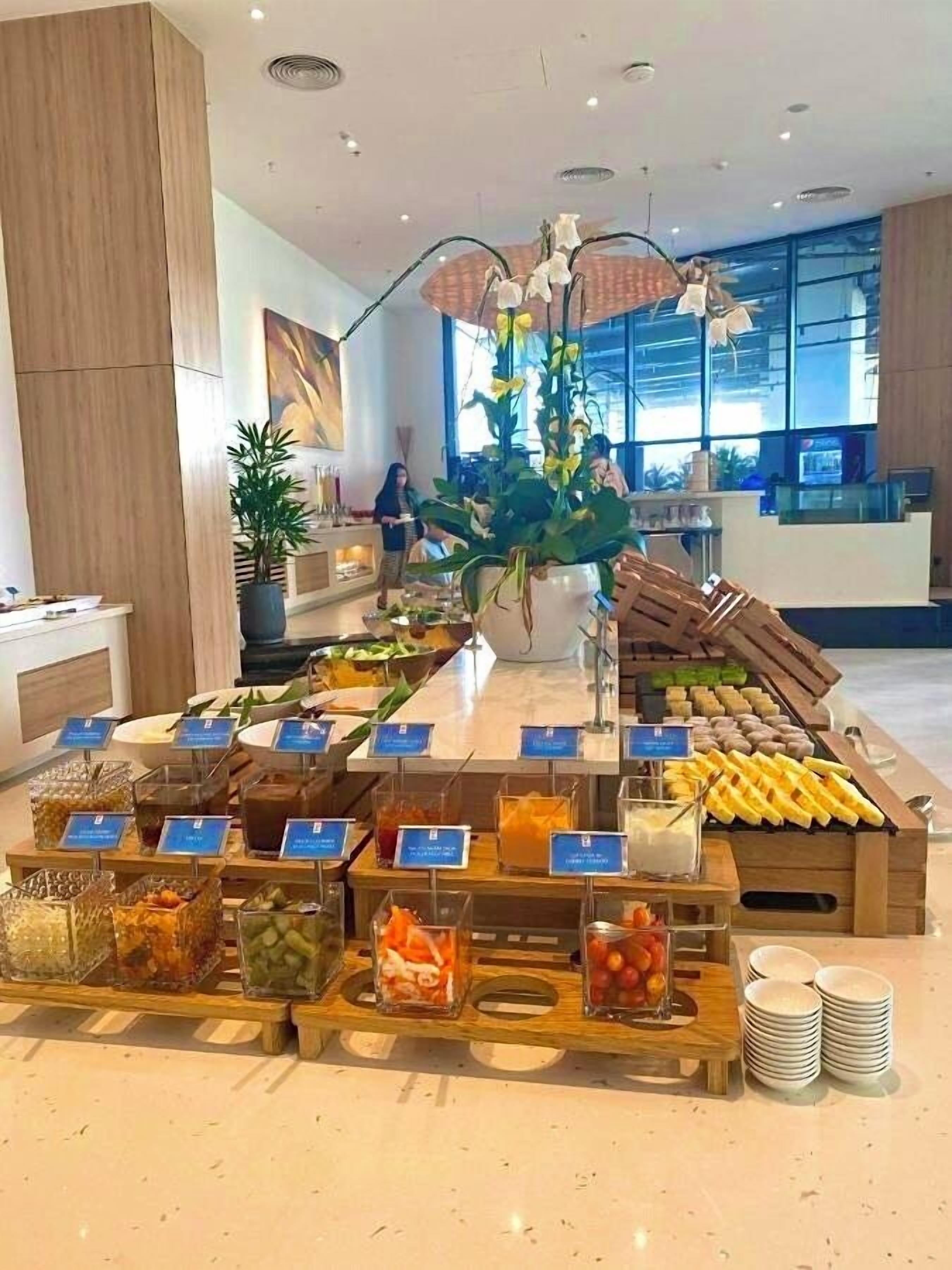 A buffet setup with various food items and a central floral arrangement.